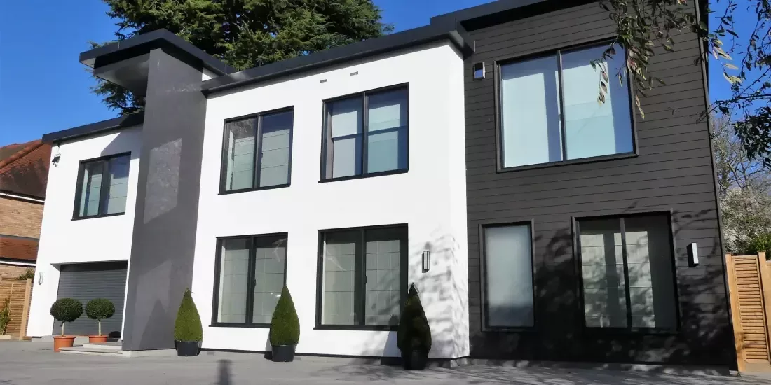 Modern home with grey and white sections and dark grey aluminium windows
